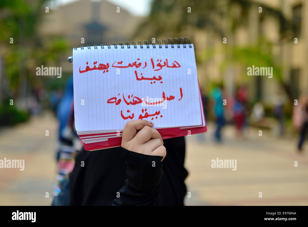 Cairo, Egypt. 21st Oct, 2014. An Egyptian student who support Muslim Brotherhood and ousted president Mohammed Morsi, holds a placard during a demonstration against military rule and to demand for release their fellows, at Cairo University, in Cairo, October 21, 2014. Anti-Coup students have launched a week-long 'breaking the siege' campaign in protest against security forces tight grip on university campuses across Egypt Credit:  Amr Sayed/APA Images/ZUMA Wire/Alamy Live News Stock Photo