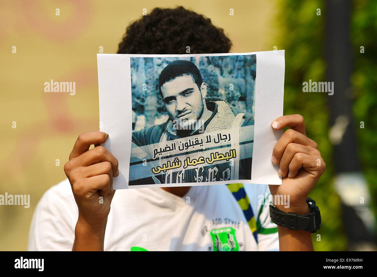 Cairo, Egypt. 21st Oct, 2014. An Egyptian student who support Muslim Brotherhood and ousted president Mohammed Morsi, holds a placard during a demonstration against military rule and to demand for release their fellows, at Cairo University, in Cairo, October 21, 2014. Anti-Coup students have launched a week-long 'breaking the siege' campaign in protest against security forces tight grip on university campuses across Egypt Credit:  Amr Sayed/APA Images/ZUMA Wire/Alamy Live News Stock Photo