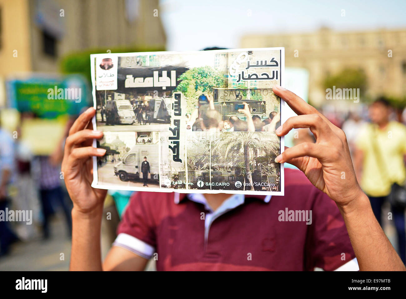 Cairo, Egypt. 21st Oct, 2014. An Egyptian student who support Muslim Brotherhood and ousted president Mohammed Morsi, holds a placard during a demonstration against military rule and to demand for release their fellows, at Cairo University, in Cairo, October 21, 2014. Anti-Coup students have launched a week-long 'breaking the siege' campaign in protest against security forces tight grip on university campuses across Egypt Credit:  Amr Sayed/APA Images/ZUMA Wire/Alamy Live News Stock Photo