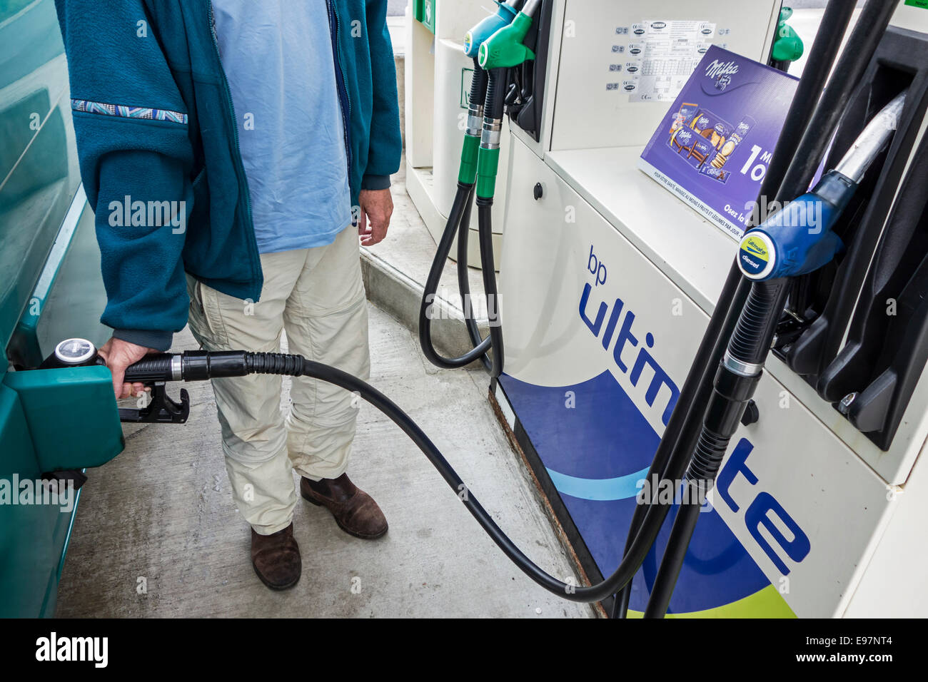 Man pumping fuel into his vehicle at BP service station Stock Photo