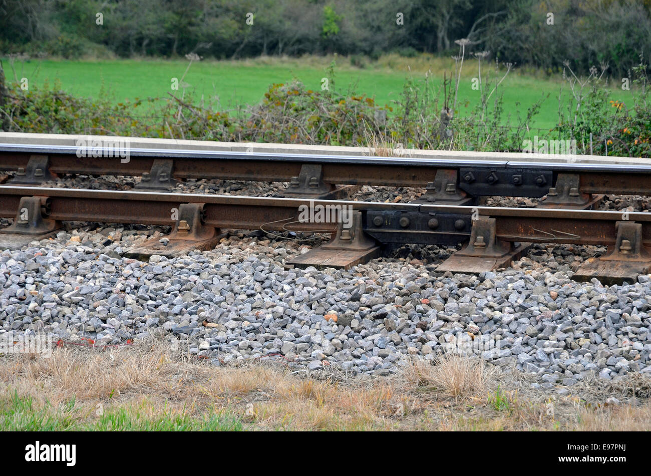 Traditional chaired railway track with bullhead rail held in cast iron chairs and wooden sleepers on a UK branch line. Stock Photo