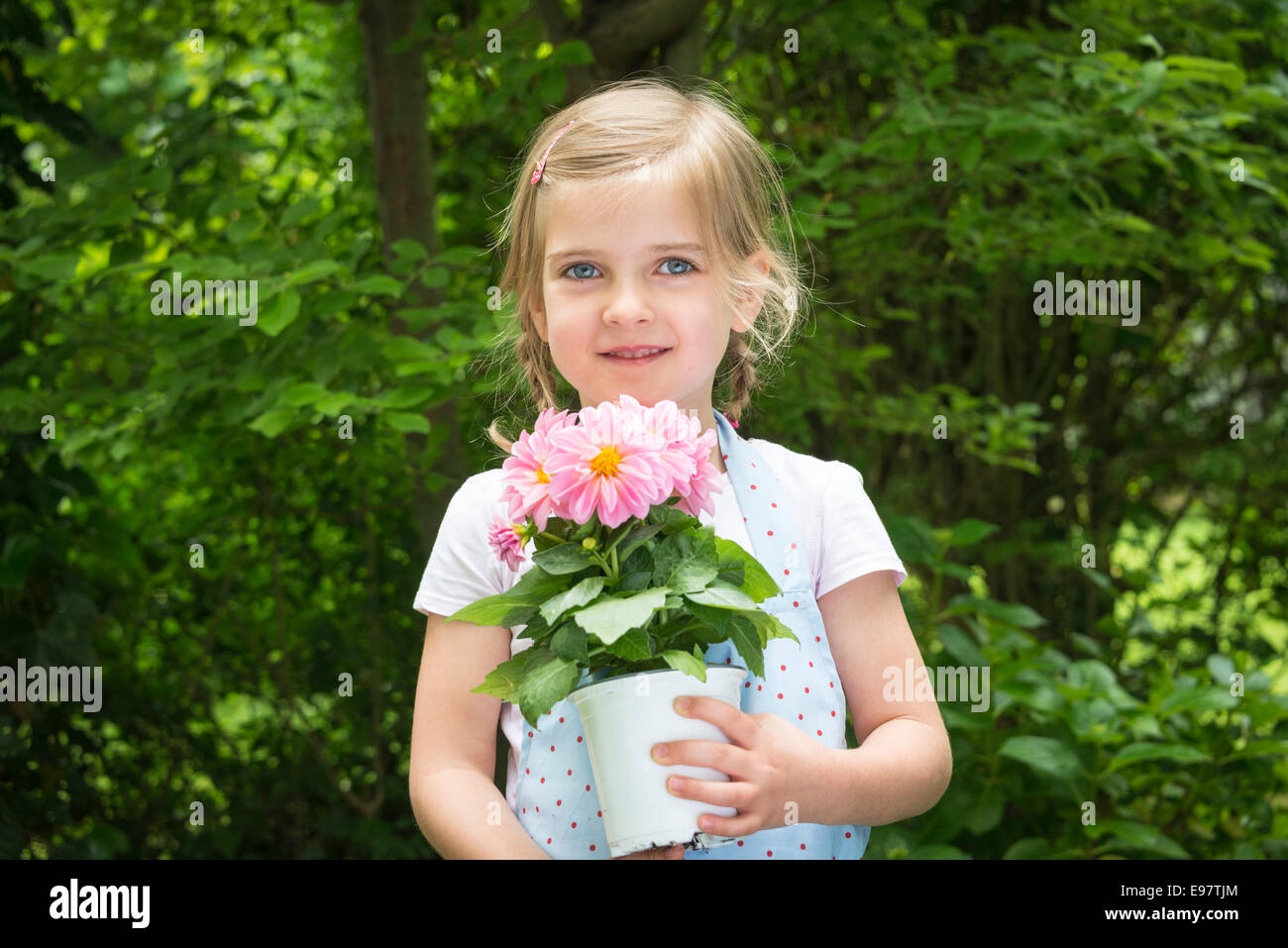 Girl gardening, holding pot with flowers Stock Photo - Alamy