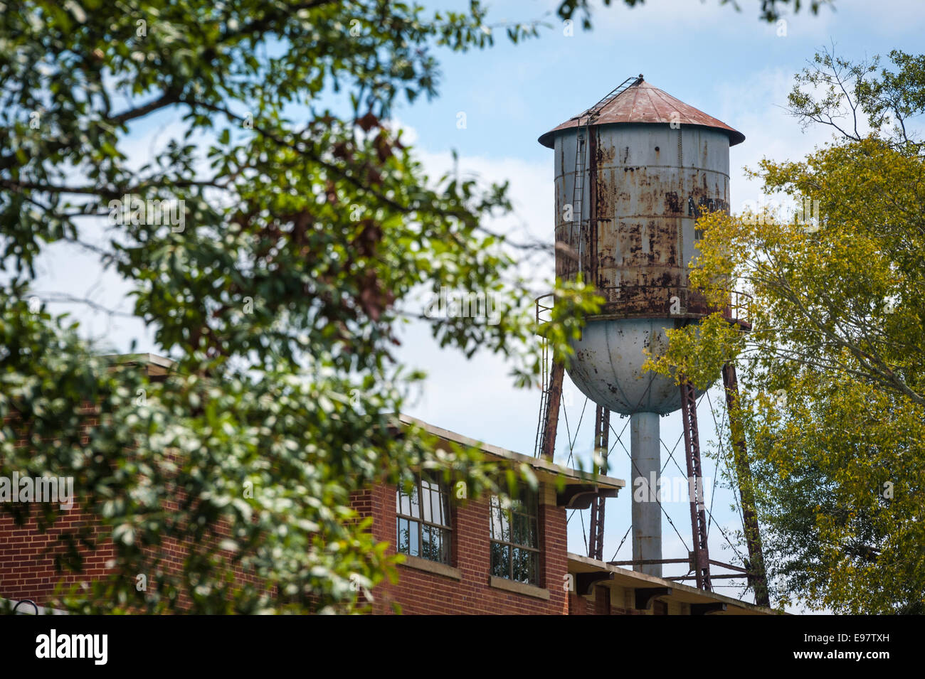 The old water tower stands above the historic 1895 Monroe Cotton Mill in Monroe , Georgia, USA. Stock Photo