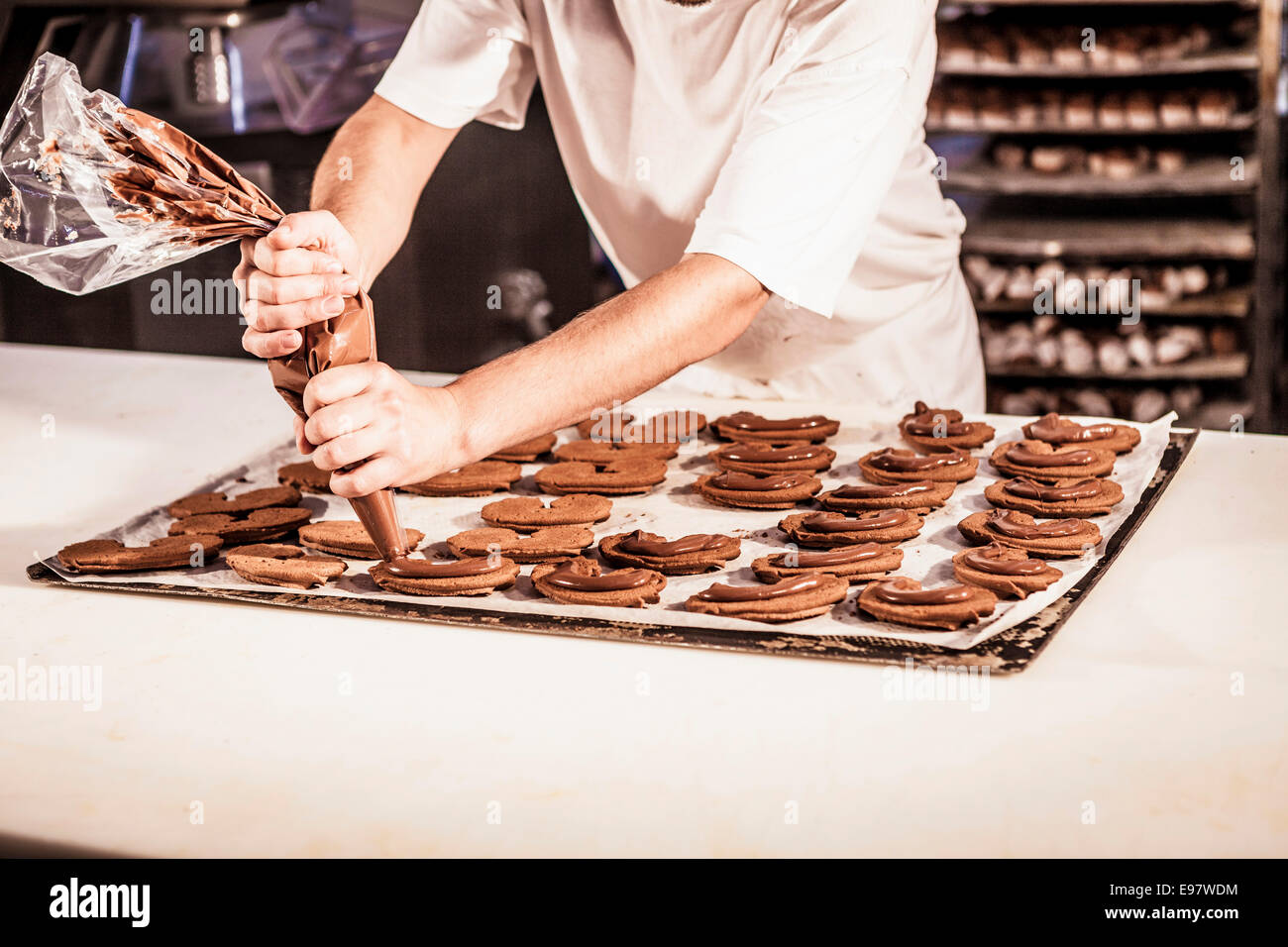Confectioner uses icing bag decorating cookies Stock Photo Alamy