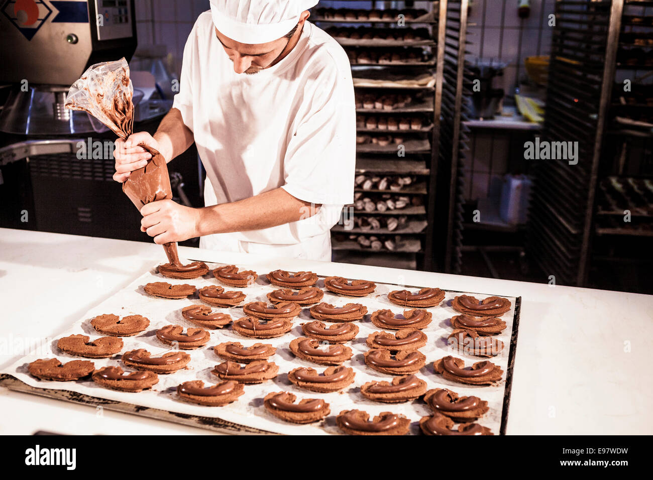 Confectioner uses icing bag decorating cookies Stock Photo Alamy