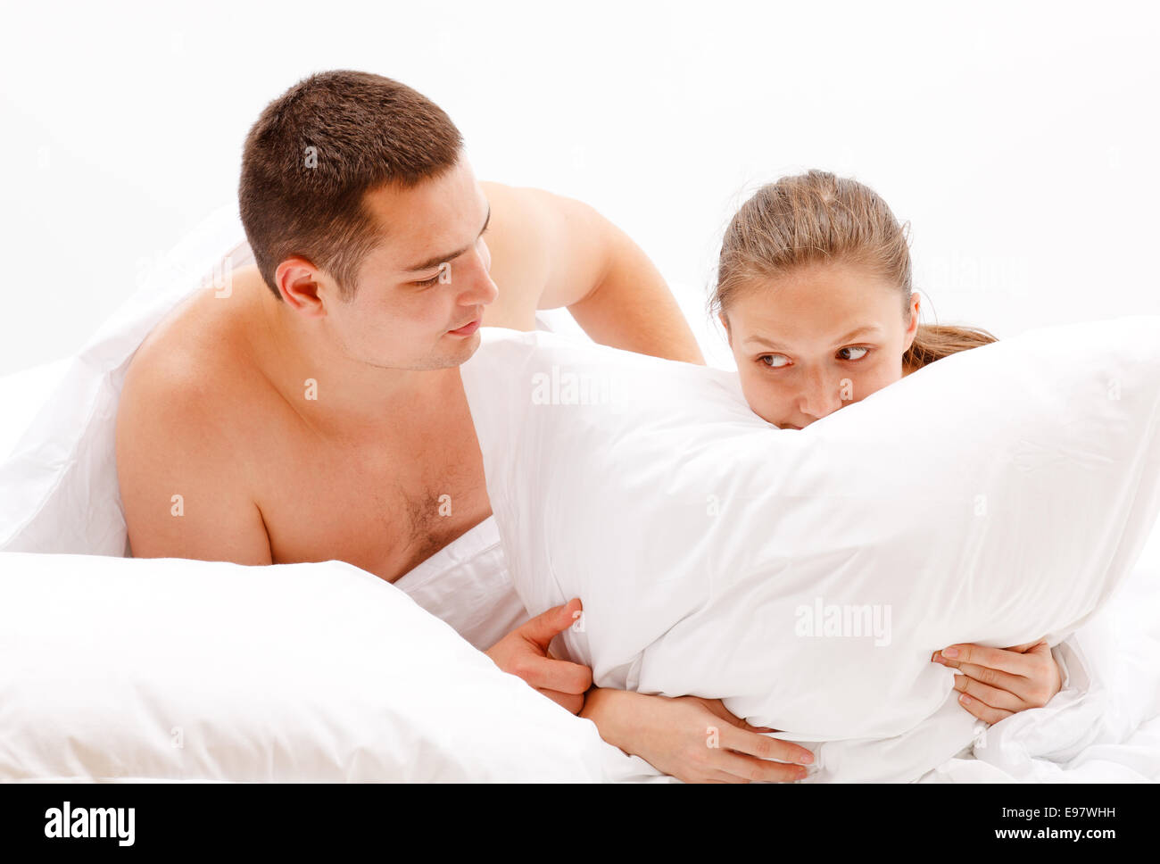 Young naked couple in bed, man comforting woman Stock Photo