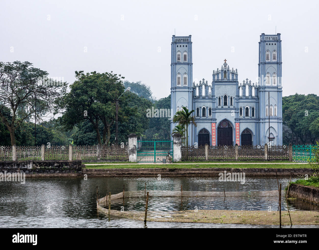 Catholic church behind pond in Vietnam Stock Photo