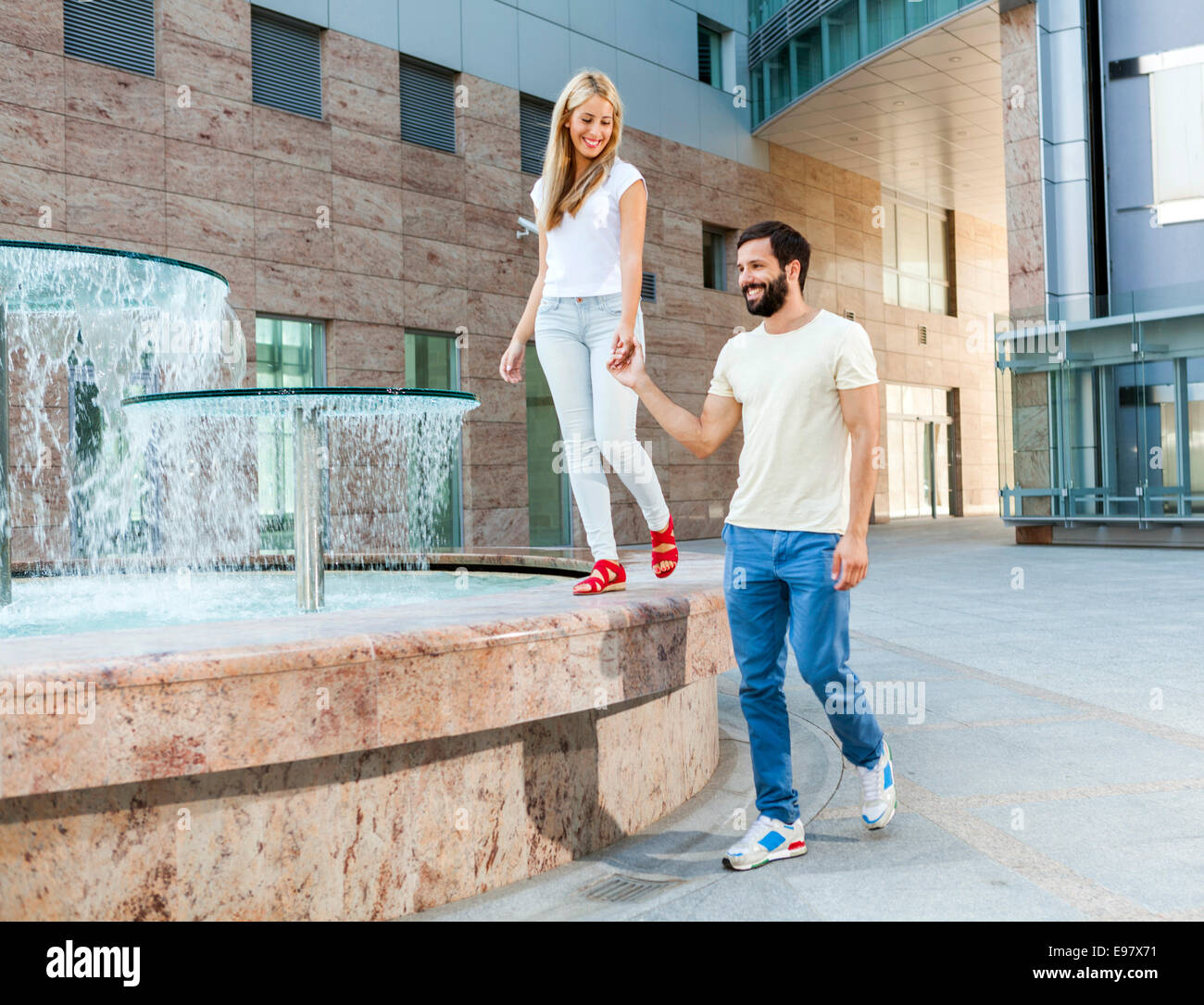 Happy young couple walking along campus Stock Photo - Alamy