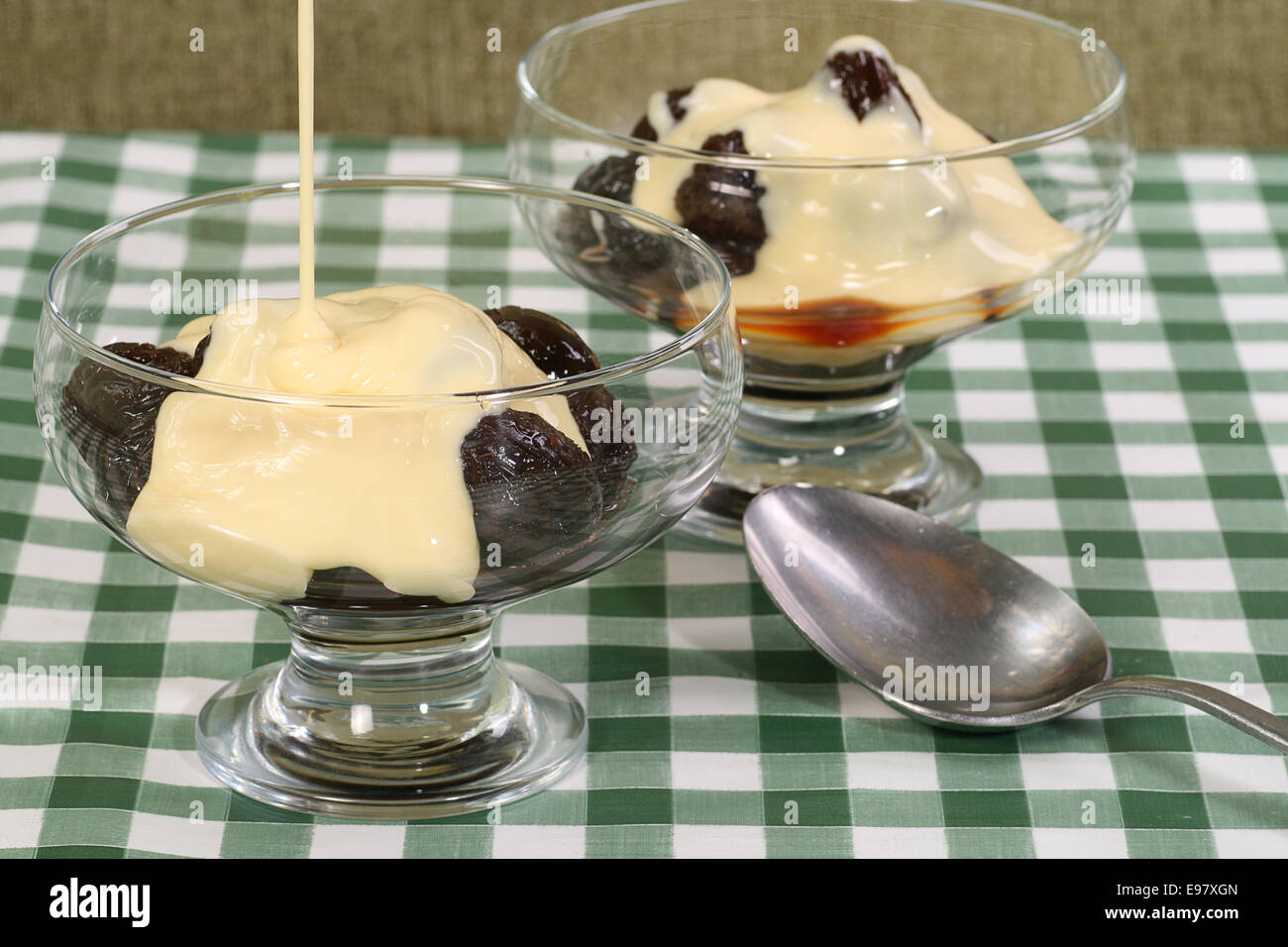 prunes and custard in a glass bowl Stock Photo