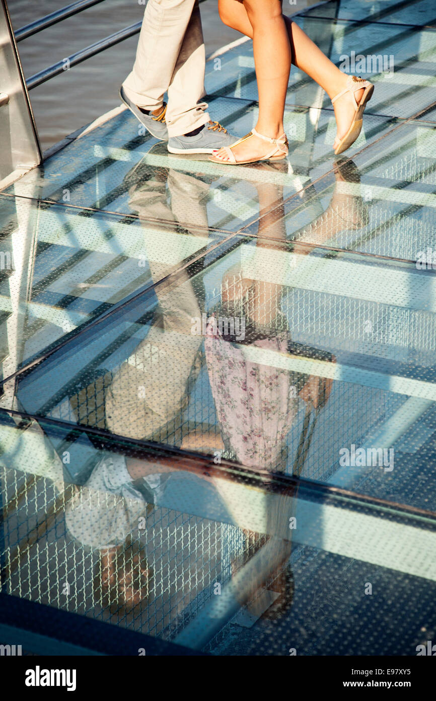 Young couple dancing along glass floor in town Stock Photo