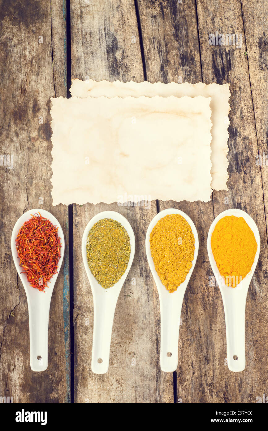 Spices recipe background. Vertical composition of variety of seasoning with vintage paper card. Top View Stock Photo