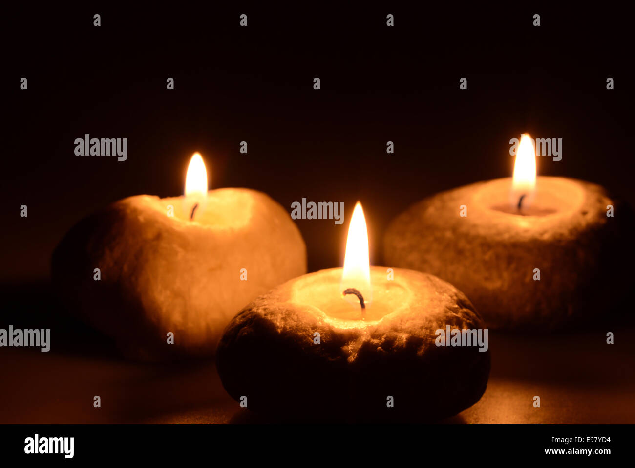 Three white candles on a black background Stock Photo - Alamy