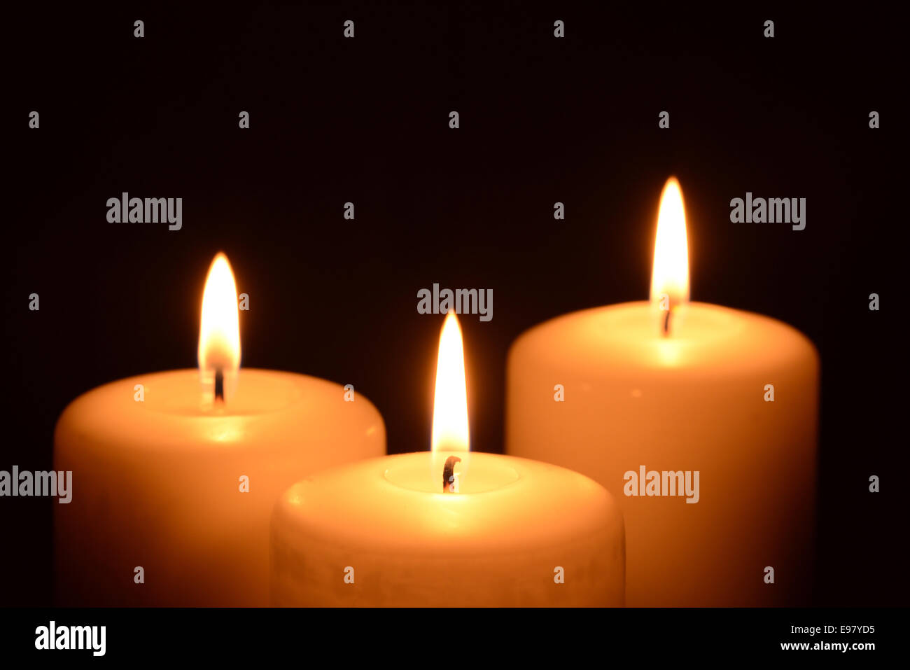 Three white candles on a black background Stock Photo - Alamy