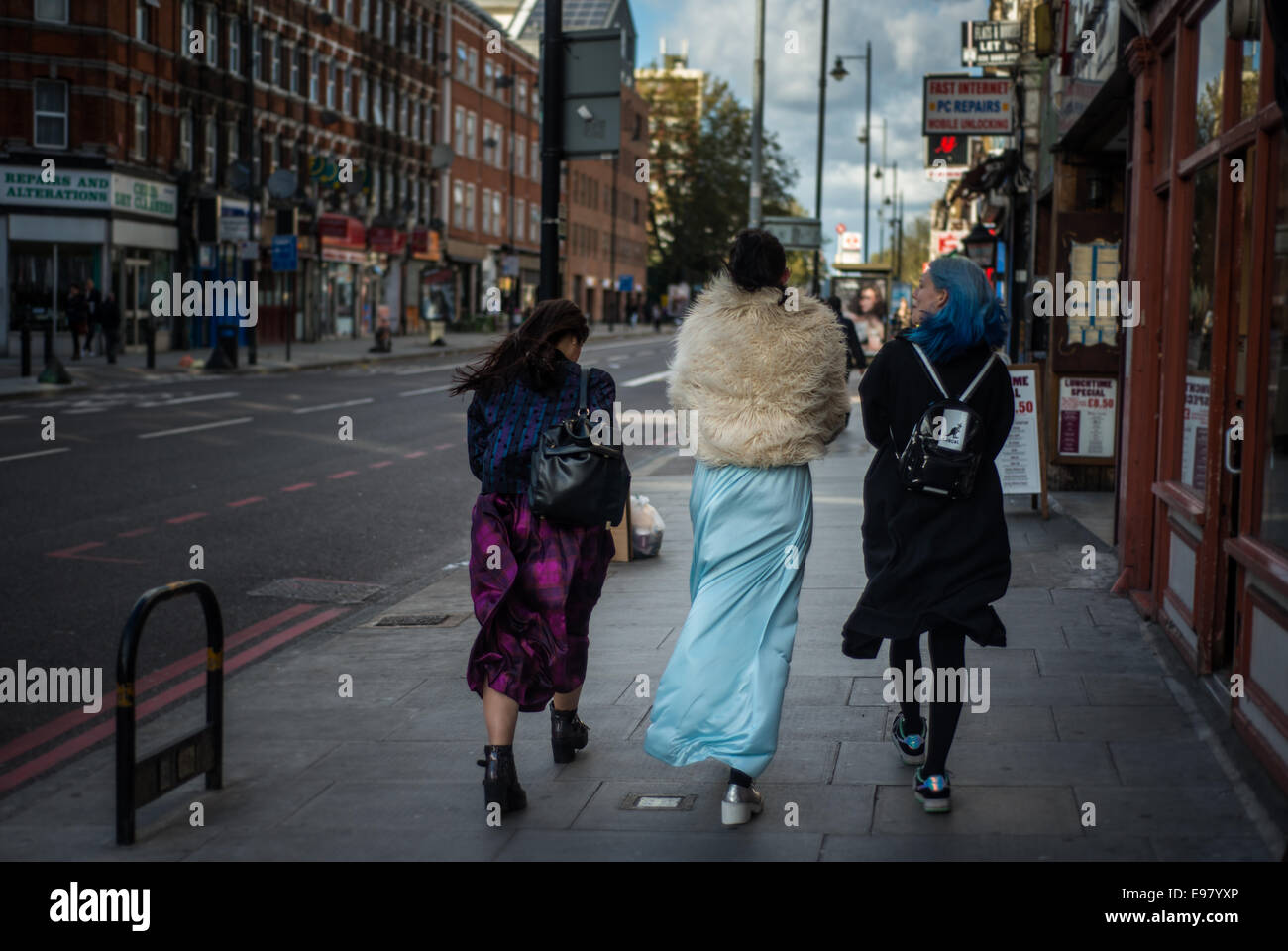 London, UK - 21 October 2014: Three young women dressed in eccentric outfit walk on Stoke Newington Road, Dalston in London. Stock Photo