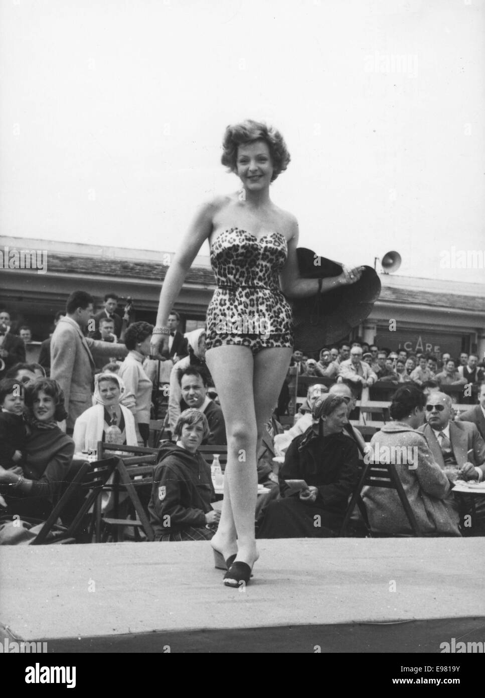 Deauville, France. 19th July, 1954. Brave Parisienne models wear pretty beach costumes despite rain and gale winds on a Deauville beach during a fashion show. © KEYSTONE Pictures/ZUMA Wire/ZUMAPRESS.com/Alamy Live News Stock Photo