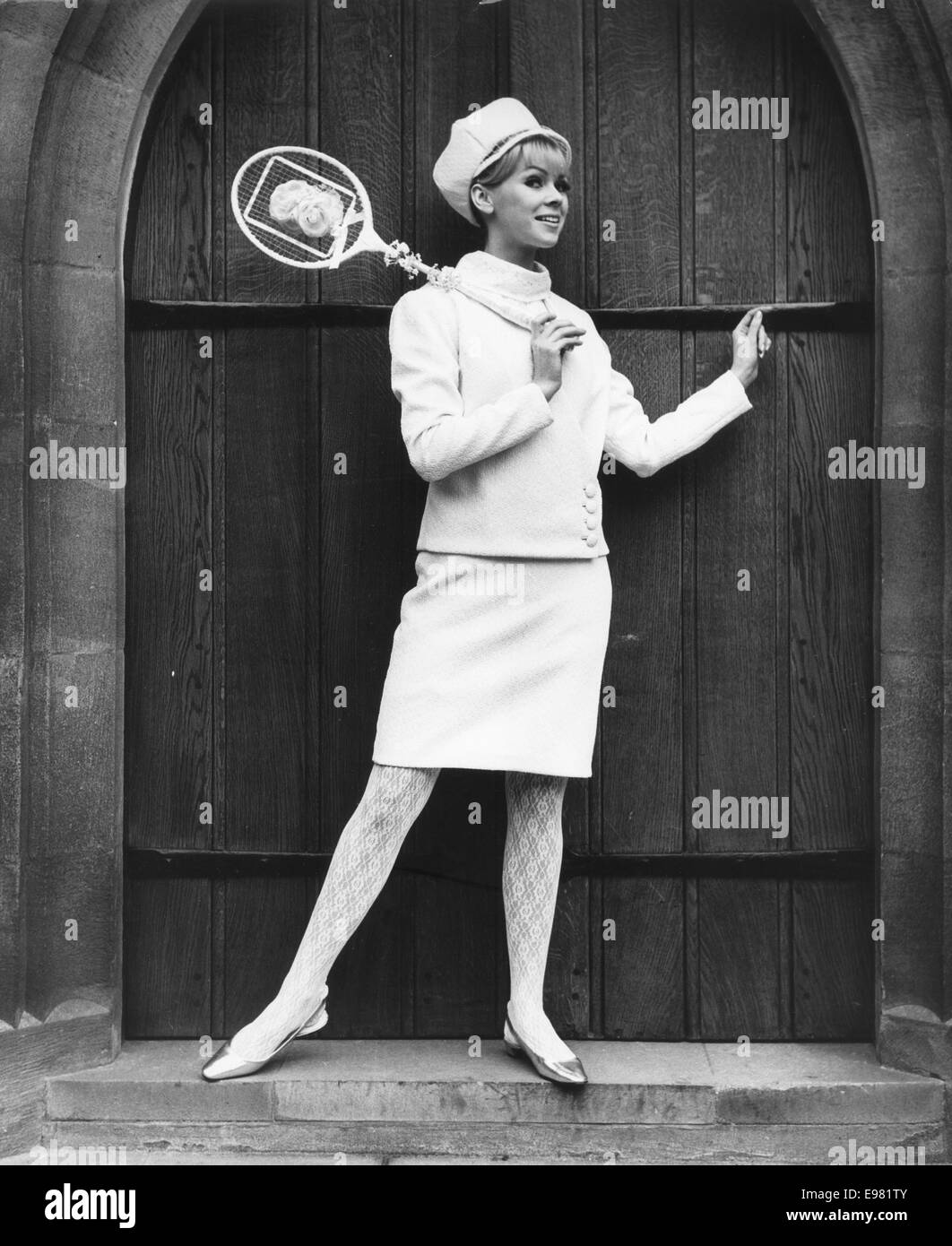 Jan 4, 1966 - London, England, United Kingdom - Model TERESA FRAEY wears 'Daredevil' a Registry office three opiece bridal suit in white Crimplene. Whit lace stockings teamed with a polo neck blouse also in white lace and matching cap headdress with a peak veil completes her outfit. The bridal range is inspired by 1966's taste for gadget-packed living and was created by designer Louis Young for the bride of 1966. The collection reveals styles that are squared, tubular and triangles. The models were instructed to walk like clockwork dolls. The grooms were robots and daleks. Young said 'Life has Stock Photo