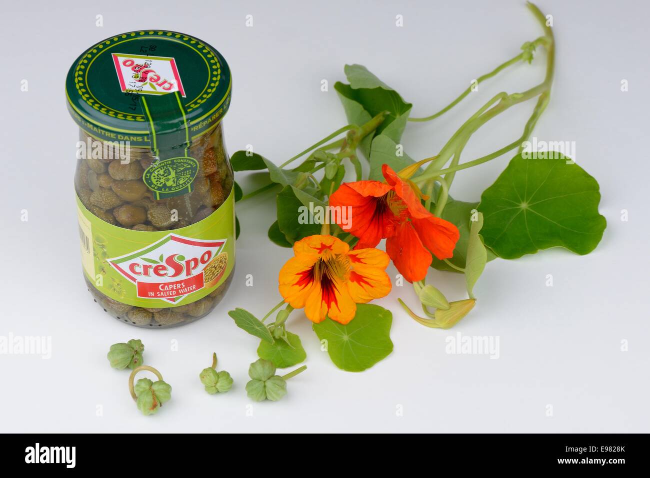 A jar of capers in brine with nasturtium flowers and seeds (poor man's