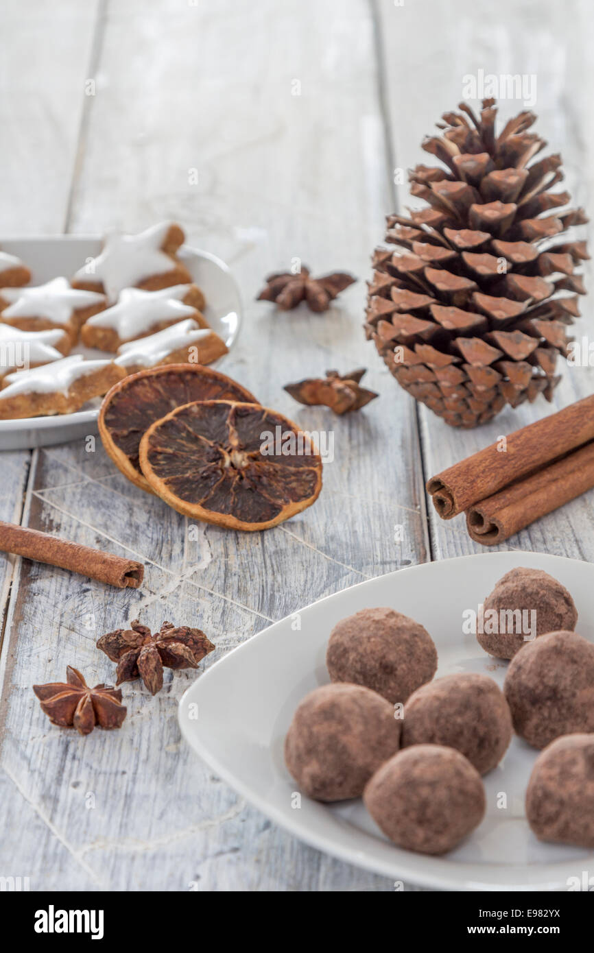 star-shaped cinnamon biscuits and marzipan potatoes with cinnamon sticks star anise and slices of dried oranges as decoration fo Stock Photo