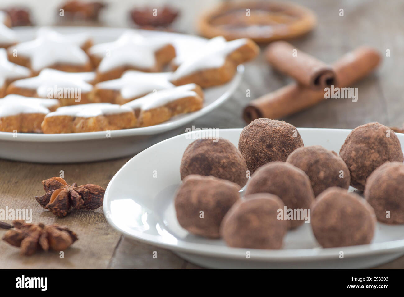 star-shaped cinnamon biscuits and marzipan potatoes with cinnamon sticks star anise and slices of dried oranges as decoration fo Stock Photo