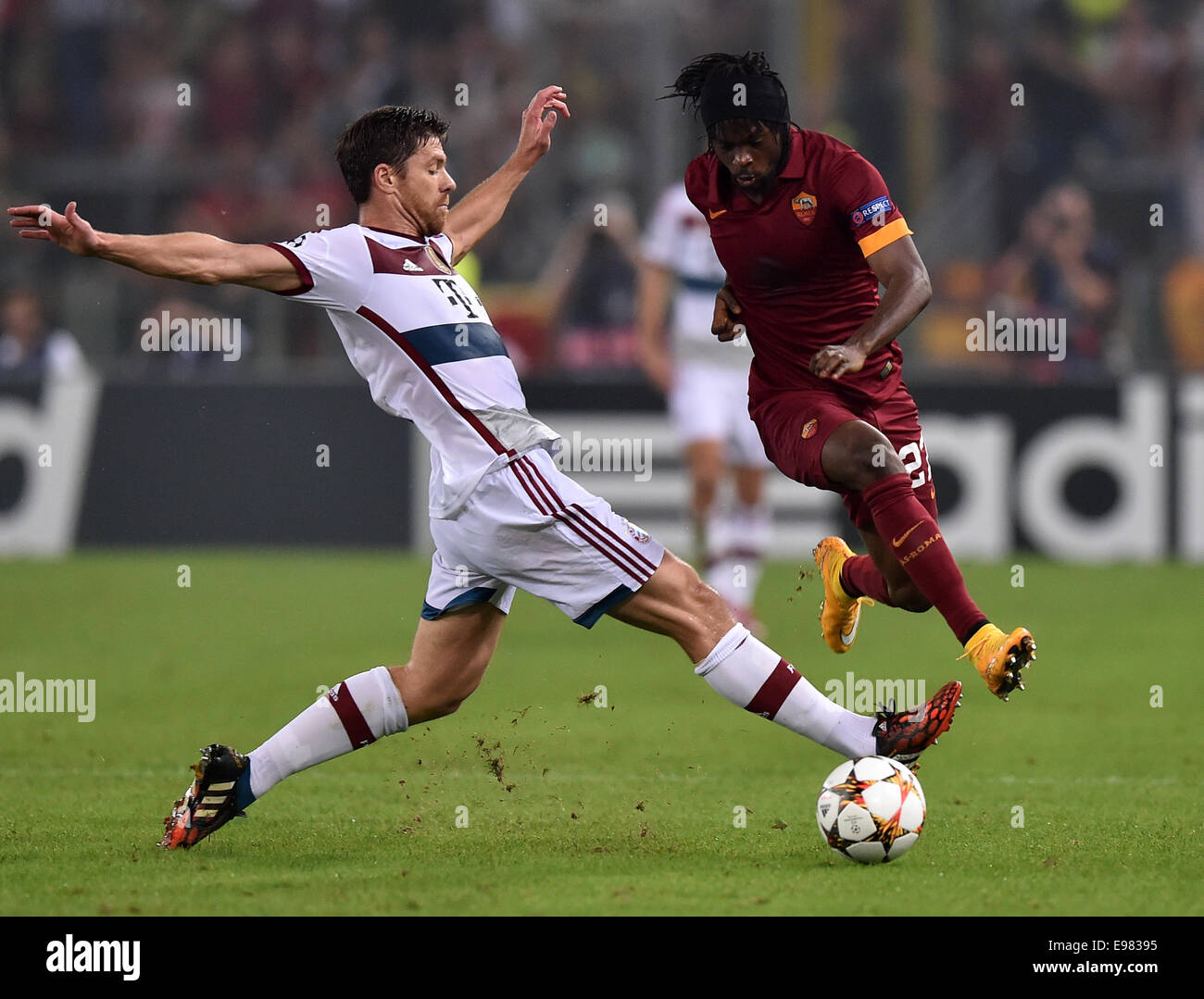 Rome, Italy. 21st Oct, 2014. Bayern Munich's Xabi Alonso (L) vies with Roma's Yao Kouassi Gervinho during their Champions League soccer match at the Olympic stadium in Rome, Italy, Oct. 21, 2014. Bayern won 7-1. Credit:  Alberto Lingria/Xinhua/Alamy Live News Stock Photo