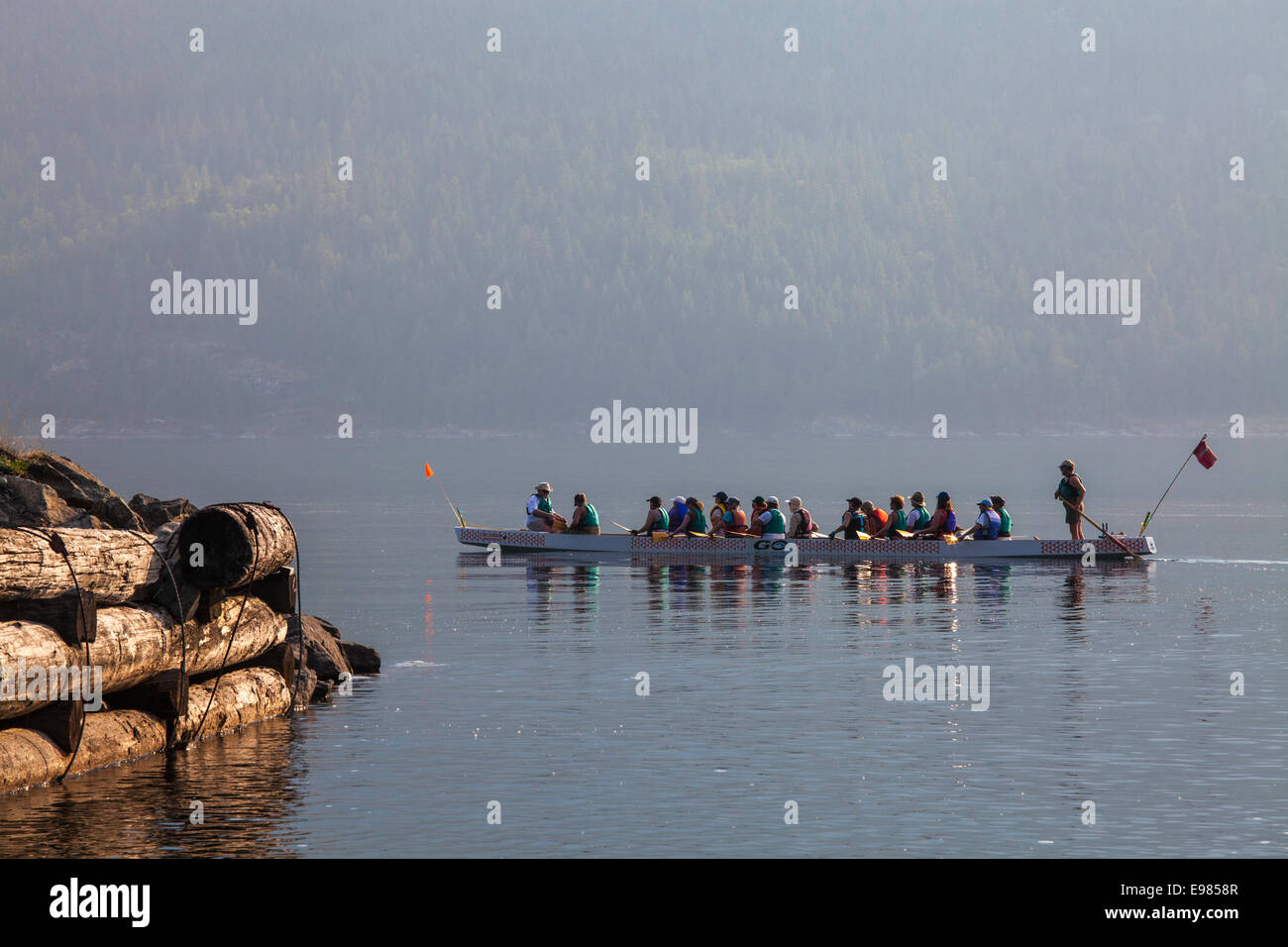 Woman rowing Dragon Boat on Slocan Lake, New Denver, Slocan Valley, West Kootenay, British Columbia, Canada Stock Photo