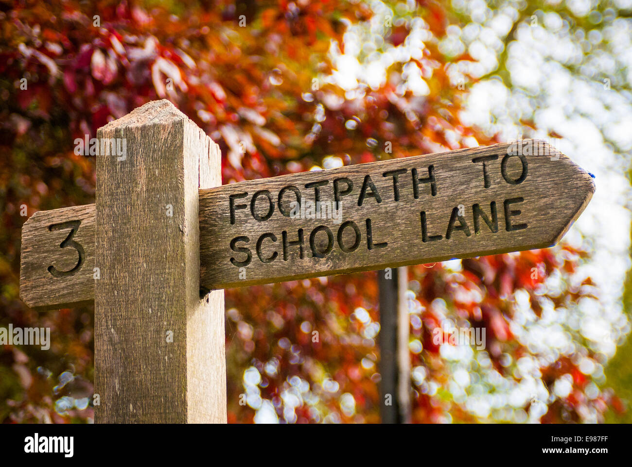 A wooden sign post points to the footpath for School Lane Stock Photo