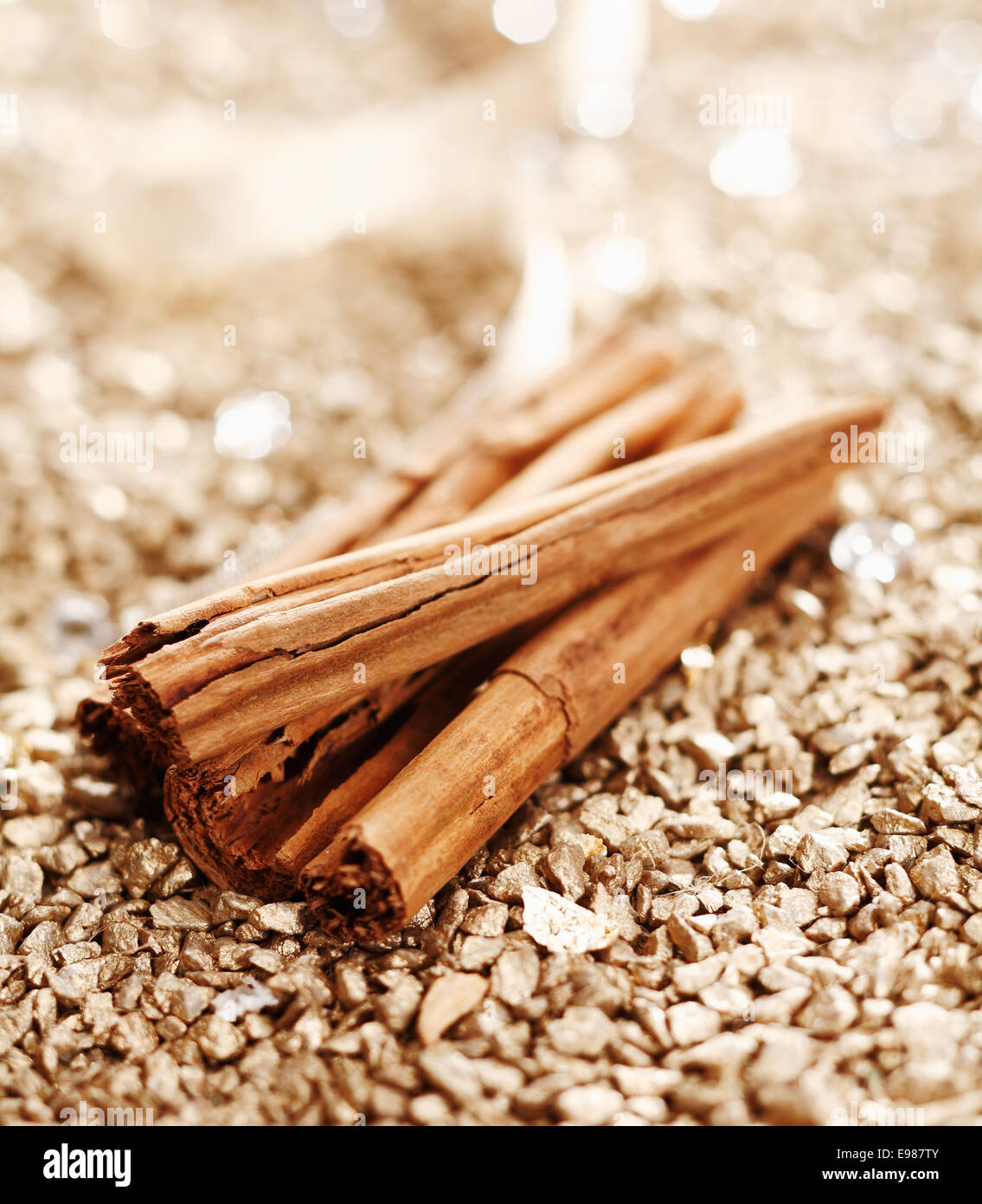 Some Cinnamon Sticks on a shiny golden background for wintery food concepts Stock Photo