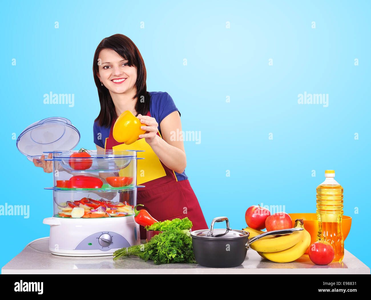 young housewife puts vegetables steamer Stock Photo