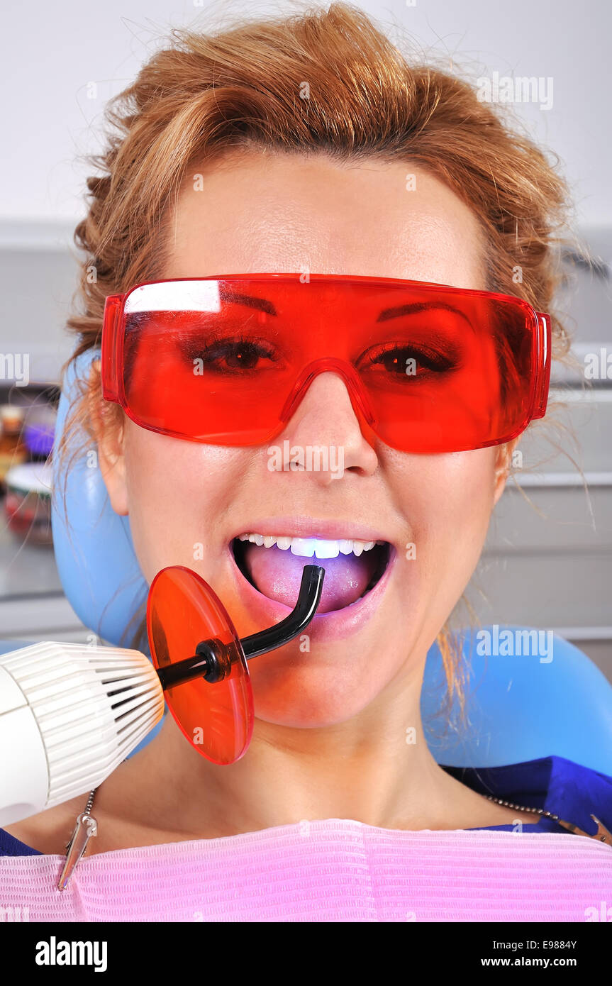 woman teeth stopping treatment with dental curing ultraviolet light equipment Stock Photo