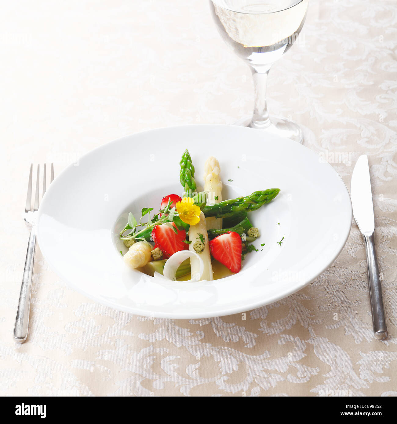 Healthy strawberry and asparagus salad with succulent green and white asparagus tips and sliced ripe red strawberries served in Stock Photo