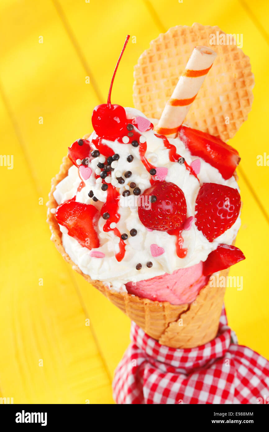 https://c8.alamy.com/comp/E988MM/colourful-party-ice-cream-cone-garnished-with-ripe-red-strawberries-E988MM.jpg