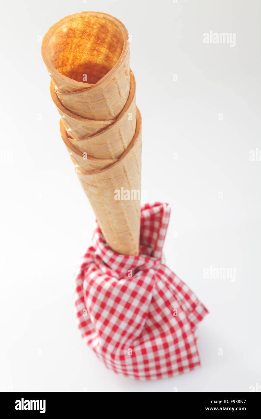 High angle view of a stack of crisp empty ice-cream cones with a red and white checkered napkin Stock Photo