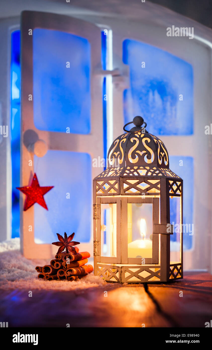 Christmas lantern with a glowing candle burning in a window