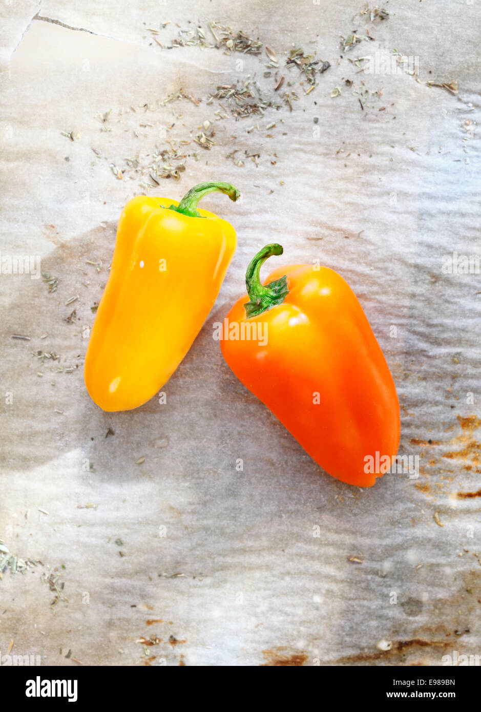 Fresh red bell peppers on a sheet of grungy used wrinkled stained oven paper Stock Photo