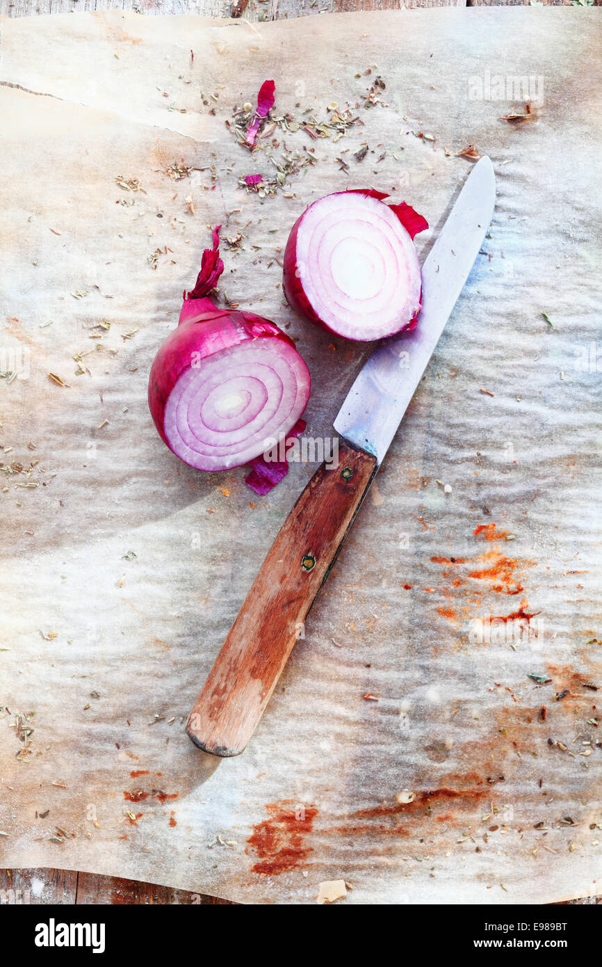 Sliced red onion with an old knife on a vintage background. For italian cuisine concepts Stock Photo