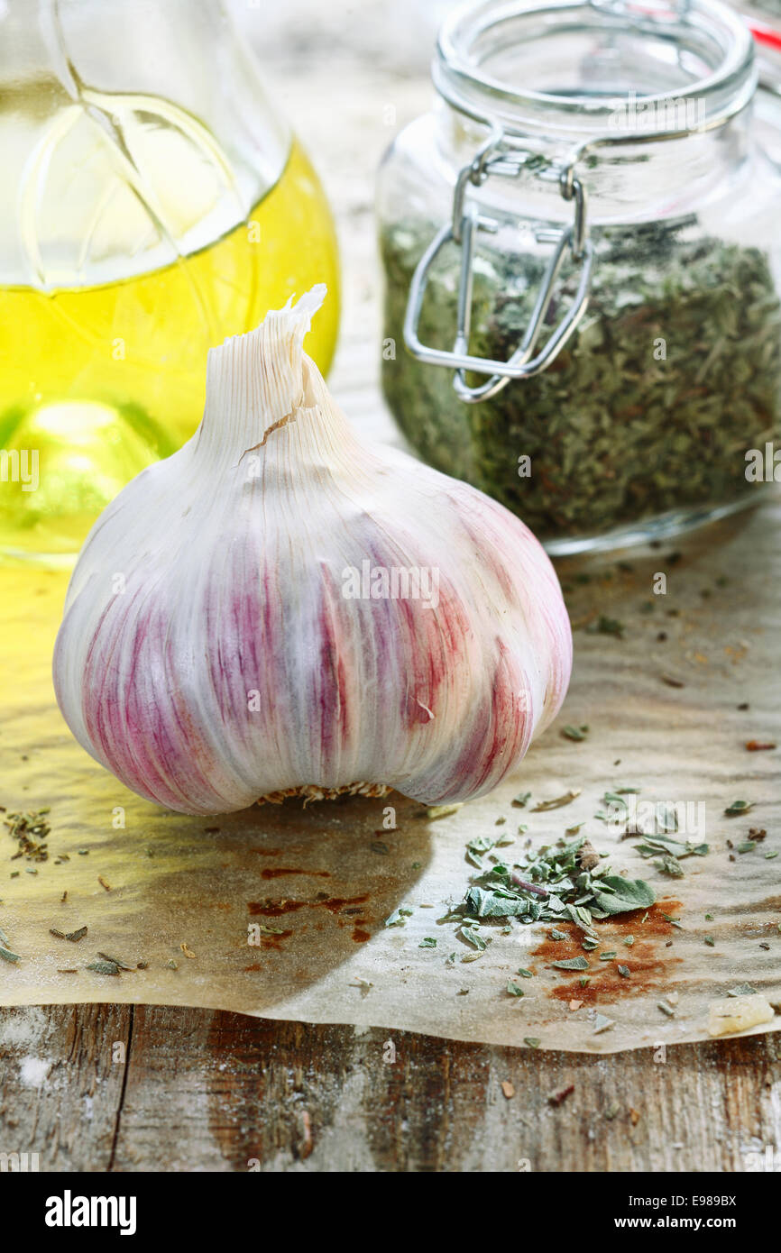 Garlic and olive oil. Italian Cuisine Ingredients on old wooden background with dried herbs Stock Photo