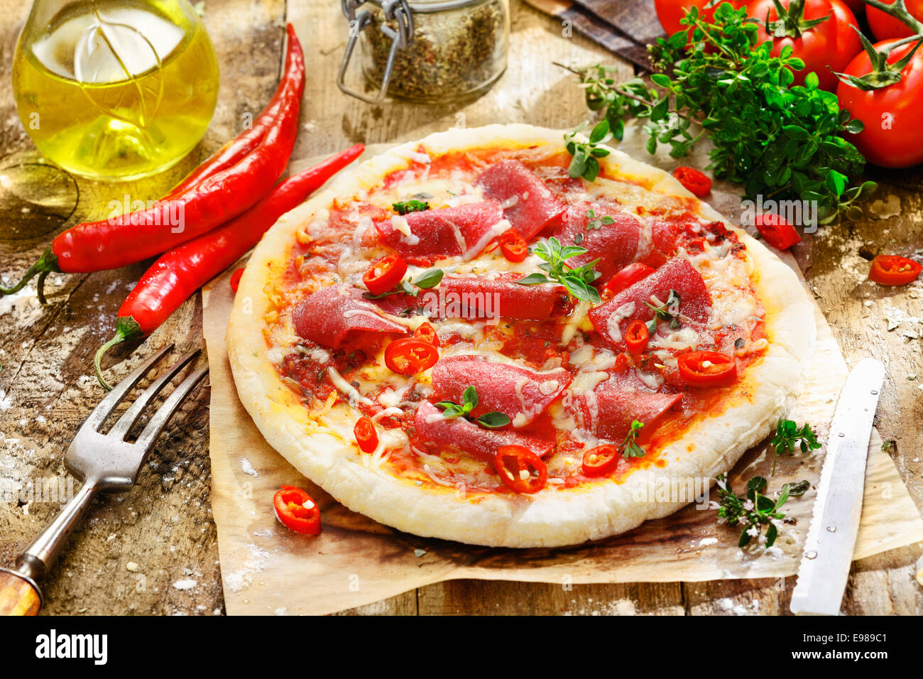 Homebaked pepperoni pizza with a delicious topping of salami, chilli  peppers, cheese and tomato on a thick golden crust Stock Photo - Alamy