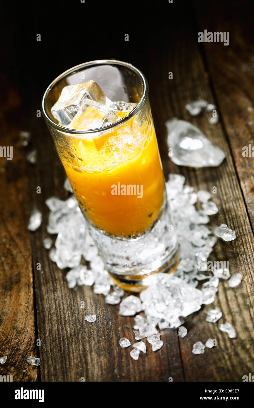 Hard Liquor Orange Juice Shooter on a countertop with crushed ice and