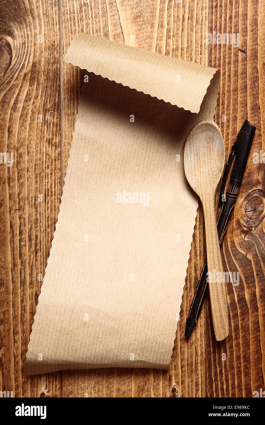 Brown paper on wood with a wooden spoon and a pen Stock Photo