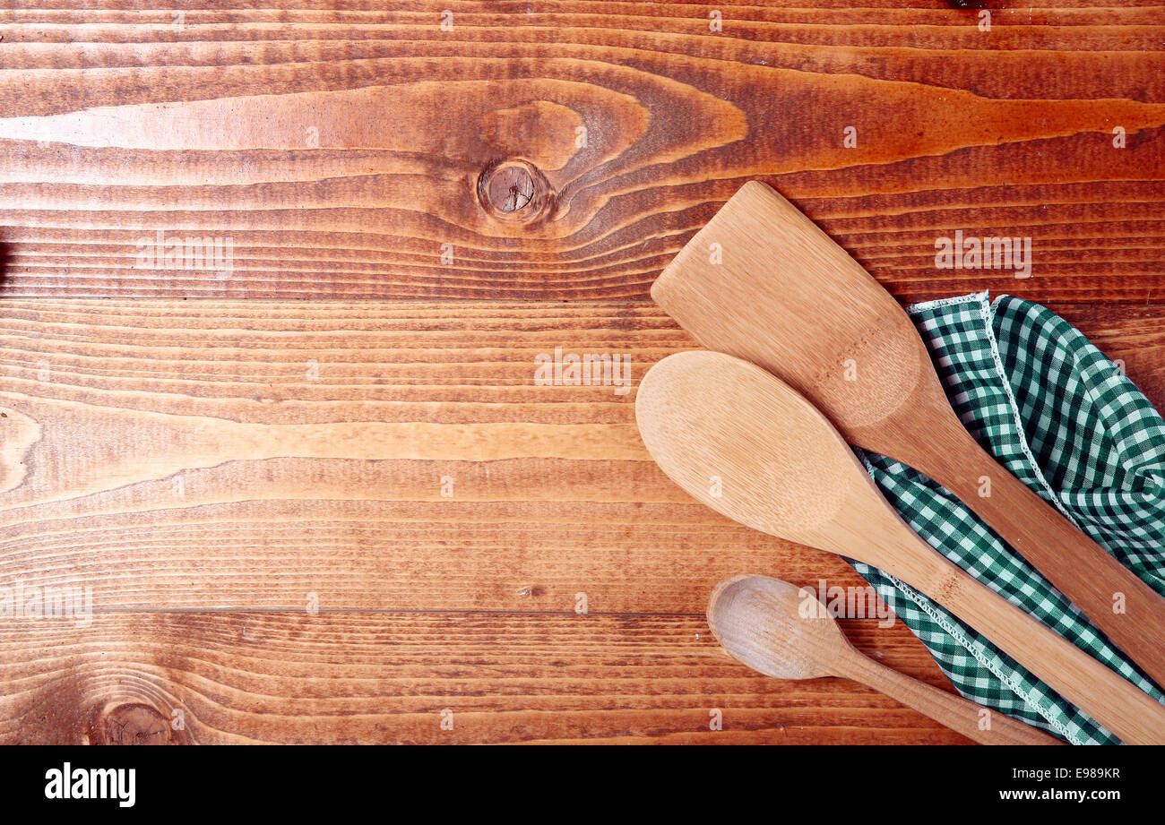 Three wooden spoons wrappen in a cloth on wooden surface Stock Photo