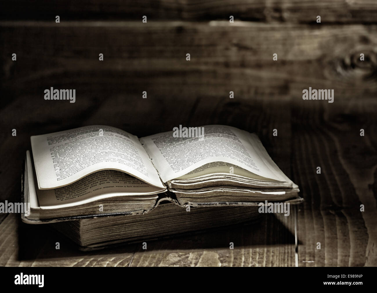 Well used open book on wooden table Stock Photo