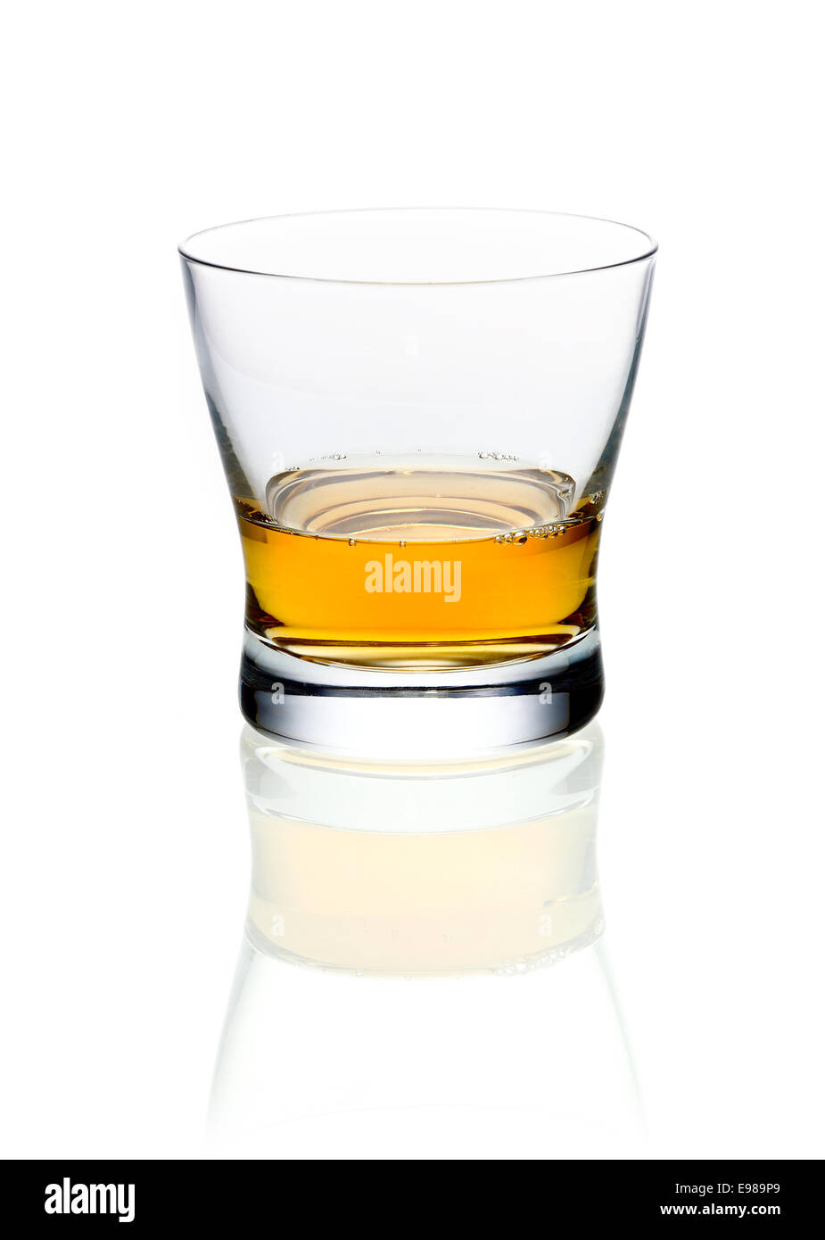 Glass of golden brandy or whisky on a white background with reflection ...