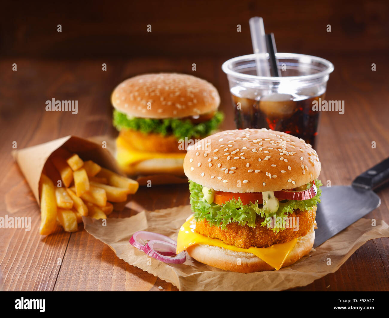 Fastfood meal made of two hamburgers, fried potatoes and soda with ice Stock Photo