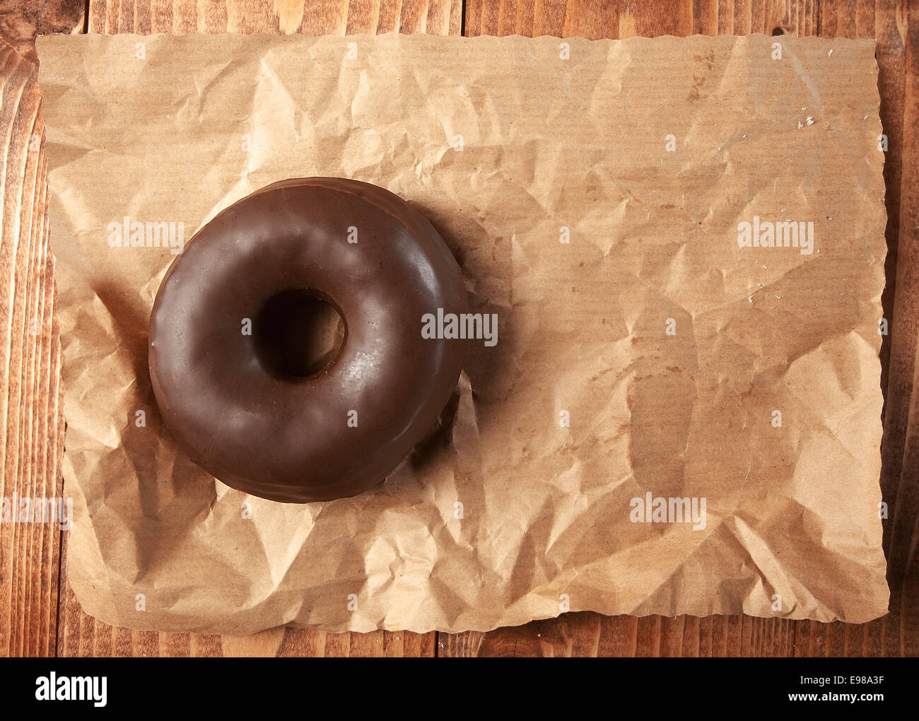 Tasty chocolate doughnut on a paper, high angle Stock Photo