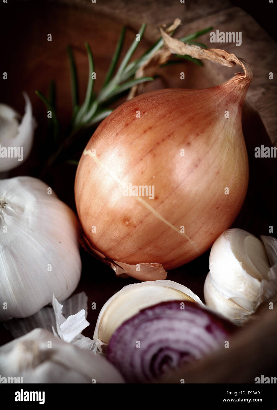 Whole fresh brown onion with garlic cloves and a slice of red onion in ...
