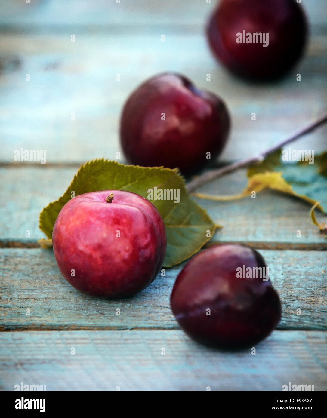 Close-up of just harvested fresh tasty cherries with leaves on a wooden table Stock Photo