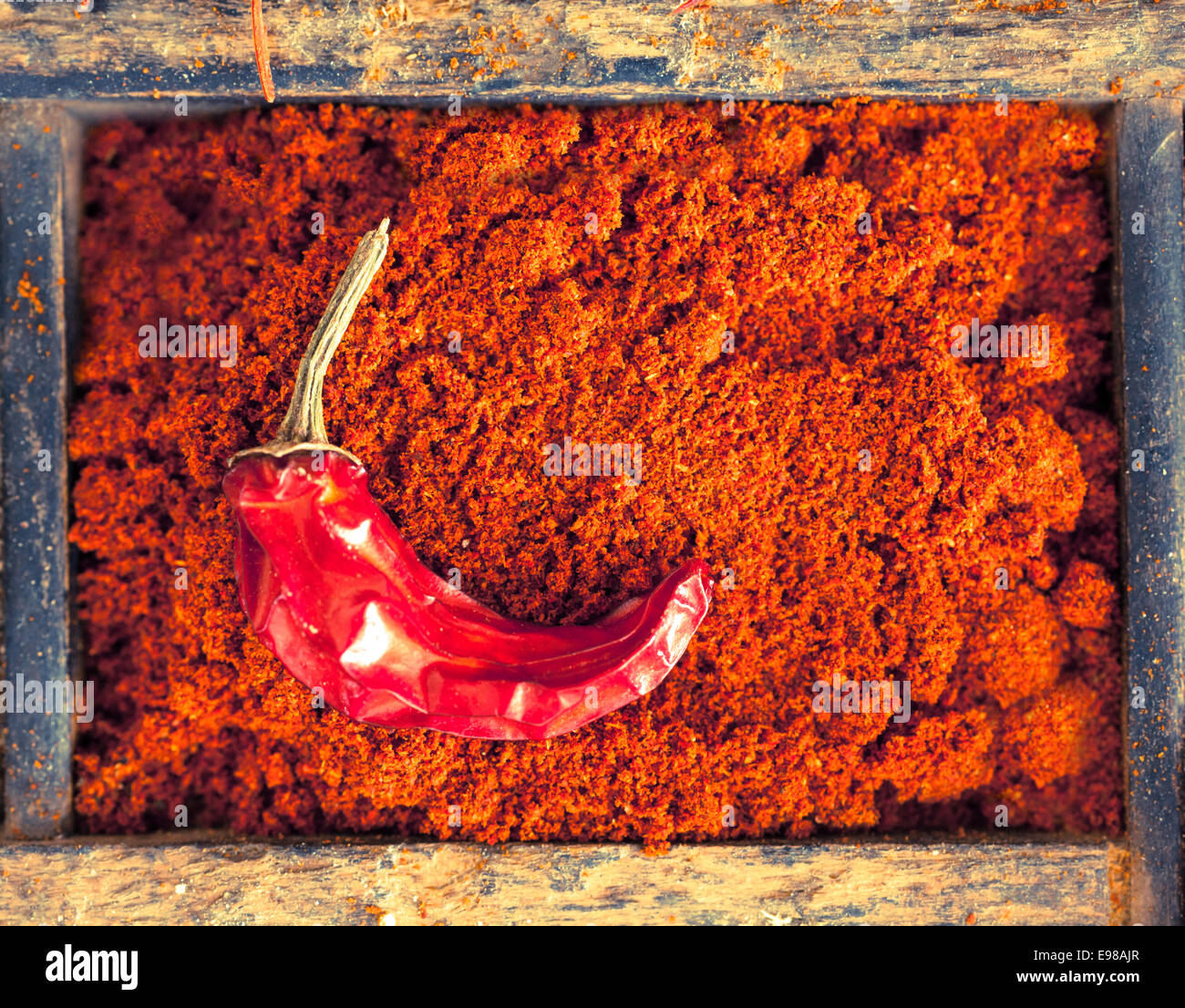 Colourful red chilli powder with a dried cayenne chilli pepper, a