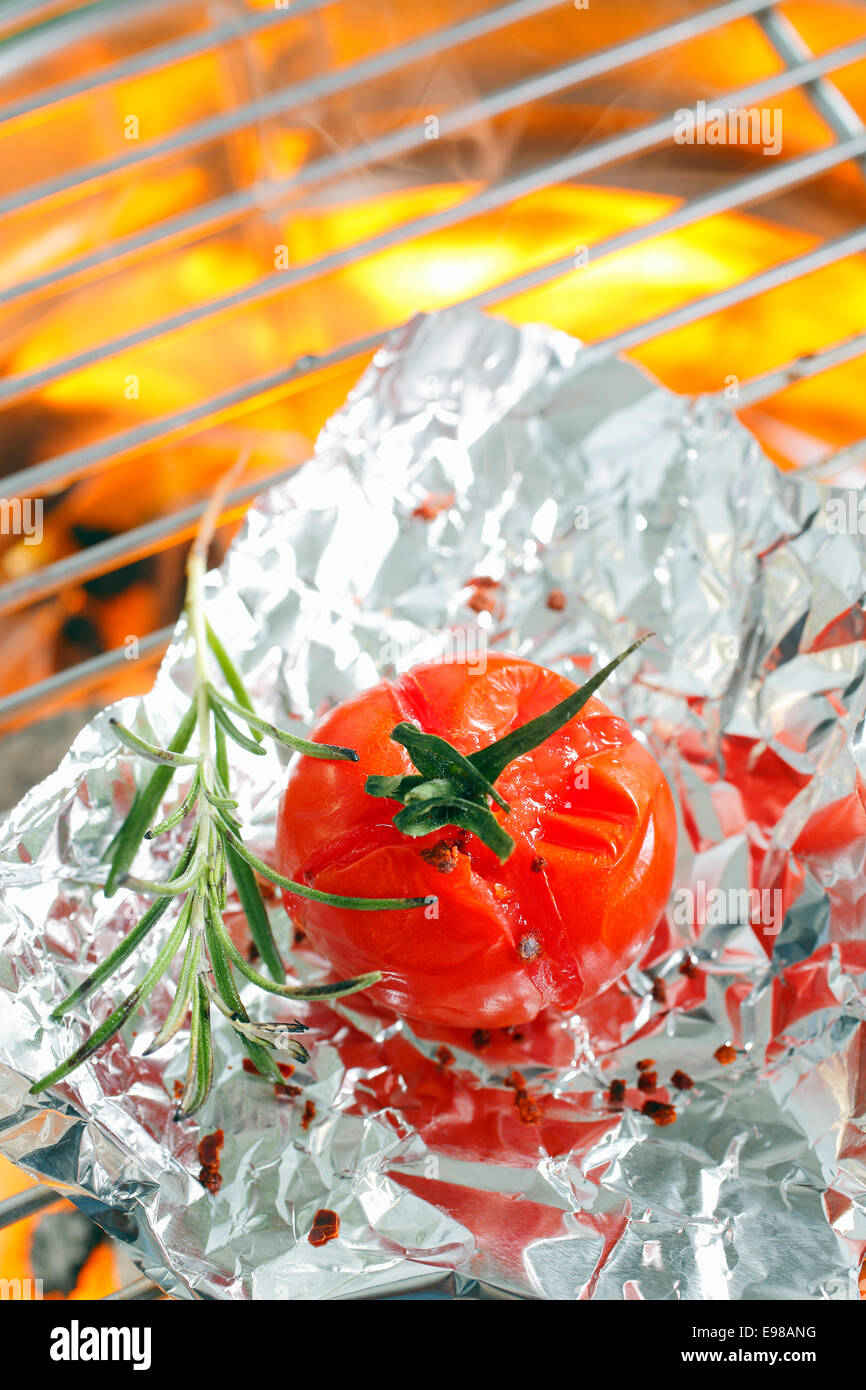 Meat Grilled in Foil on Flaming BBQ Grill. Barbecue cooking flaming grill  grid Food Background in aluminum foil. Portrait of the cooking food with  alu Stock Photo - Alamy