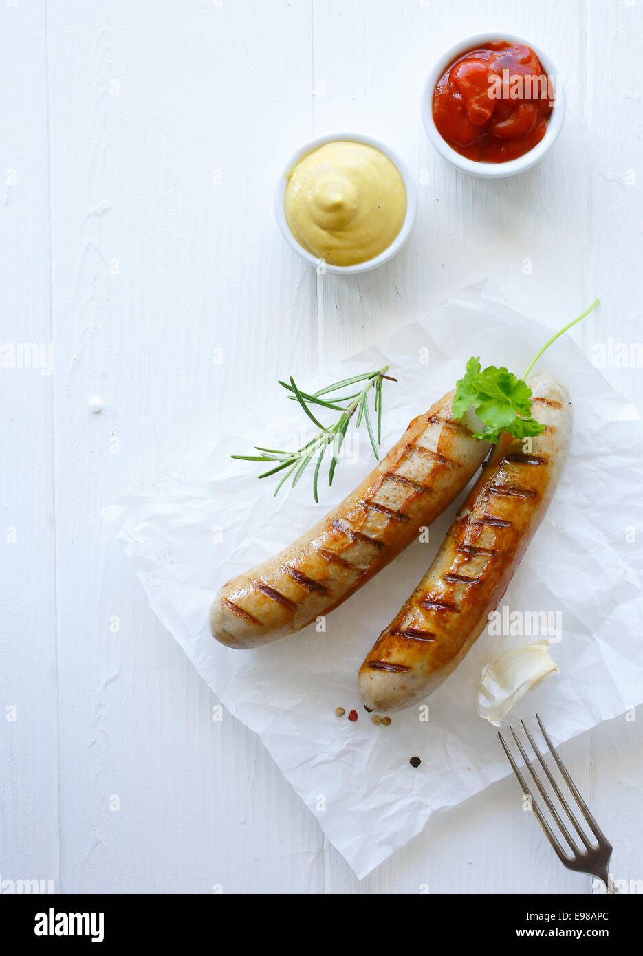 Grilled bratwurst with ketchup and mustard dip Stock Photo