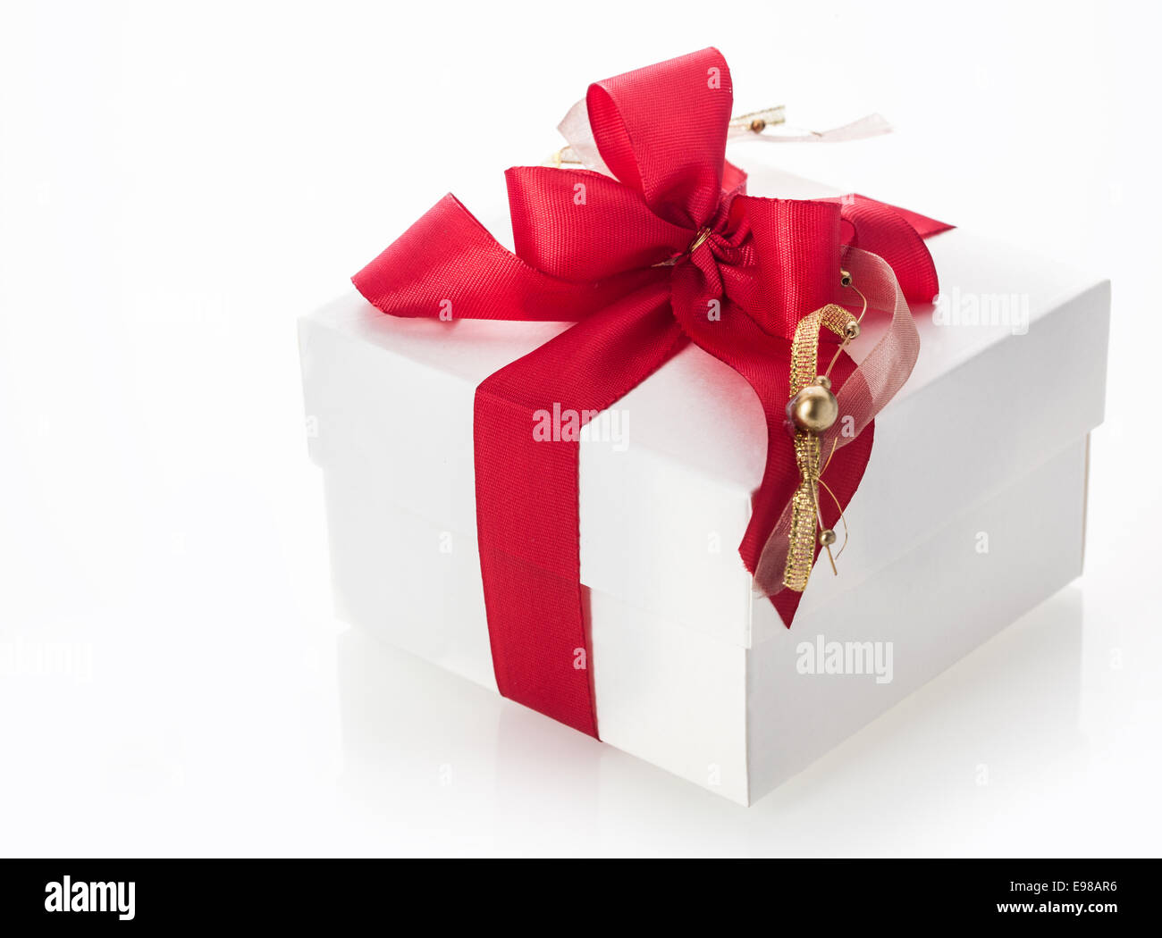 White gift box tied with a pretty red ribbon and bow decorated with a ...
